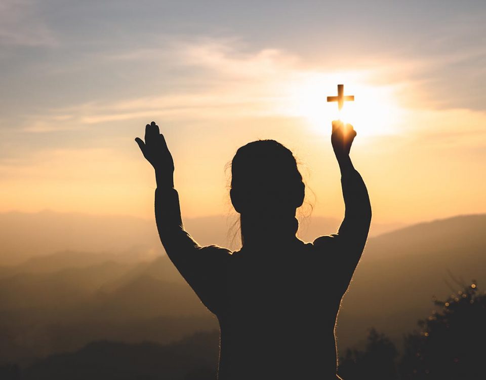 woman holding up a cross