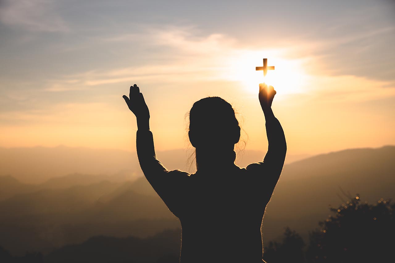 woman holding up a cross