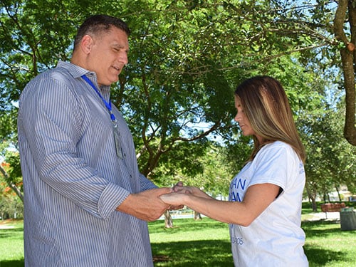 two people praying while holding hands