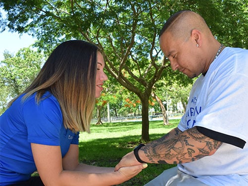 two people praying while holding hands