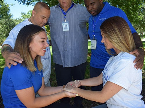 a group of people praying at faith in recovery